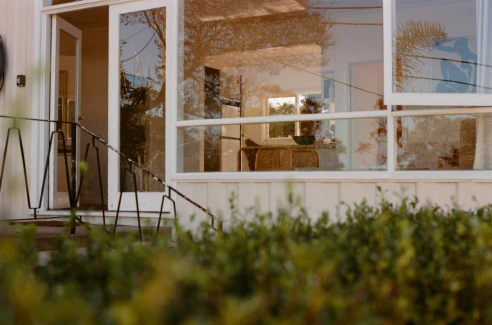 Front door area of Doma Short Point with stairs and windows. Door open with view of living room and kitchen